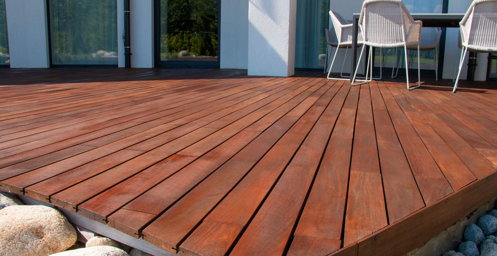 Gros plan sur le grain et les veinures naturelles d'une lame de terrasse en bois thermo-traité, avec finition mate contemporaine et surface propre