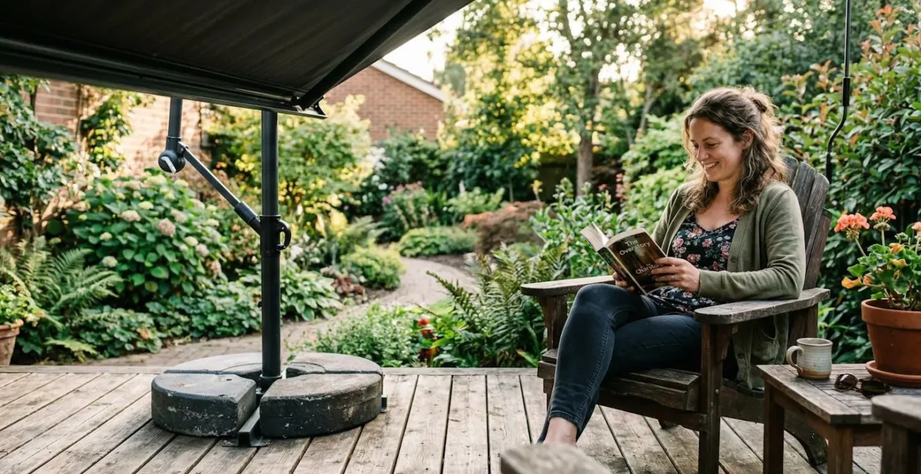 Terrasse en bois avec kit de lestage visible au pied d'un store, jardin en arrière-plan