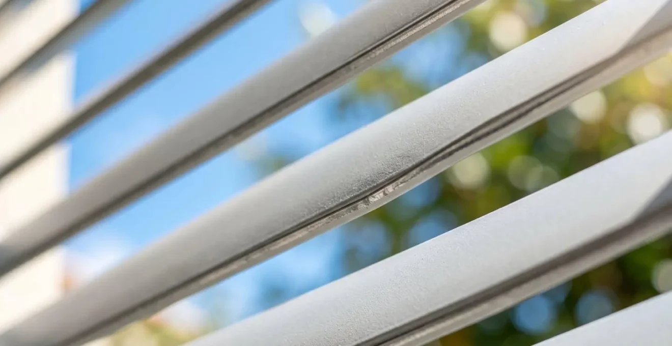 Lames en aluminium de couleur claire d'une pergola bioclimatique réfléchissant la lumière du soleil