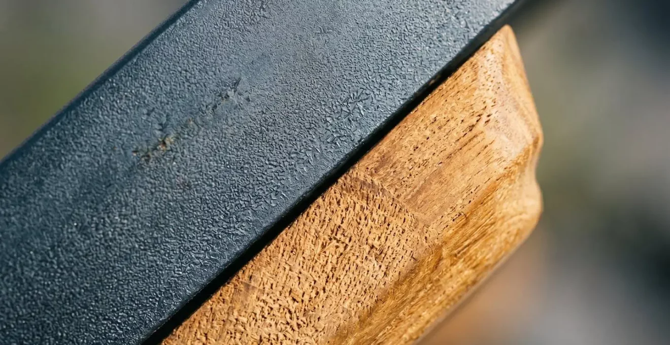Gros plan sur les textures de matériaux de mobilier extérieur : métal traité et bois naturel